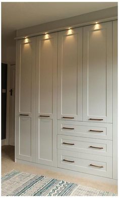 a large white closet with many drawers and lights