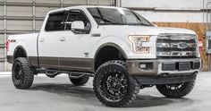 a white truck with black accents parked in a garage