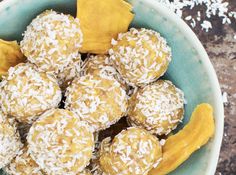 a bowl filled with coconut covered desserts on top of a table