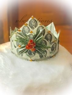 a crown made out of dollar bills sitting on top of a white furnishing