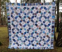 a blue and white quilt hanging from a tree