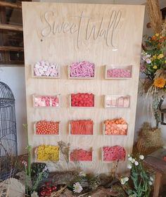 there is a sign that says sweet treats on the wall next to flowers and plants