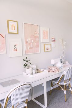 a white desk with chairs and pictures on the wall