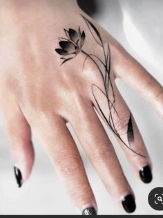 a woman's hand with a flower tattoo on it