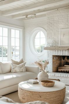 a living room filled with furniture and a fire place in front of a white brick wall