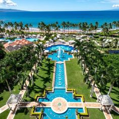 an aerial view of the resort and pool area with palm trees in the foreground