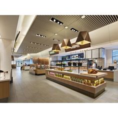 the interior of a restaurant with lots of counter space and lights hanging from the ceiling