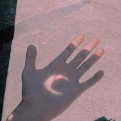 a person's hand casting a shadow on the ground