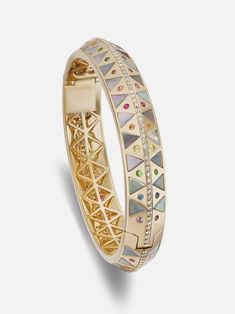 18k yellow gold knife edge bangle with mother of pearl inlay, diamonds and multicolored gemstones in sapphire, blue topaz and amethyst details. A regal combination of inlay stone, sparkling gems and substantial gold, the Chubby Stone Inlay bangle has all the elements of a masterpiece. Triangles of iridescent mother of pearl are set alongside a rainbow of round gemstones and a row of white diamonds. A single hinge and additional safety clasp make this bangle both bold and comfortable. Made to ord Luxury Jeweled Yellow Gold Bracelets, Luxury Multicolor Bangle, Luxury Multicolor Bangle For Formal Occasions, Luxury Multicolor Bangle Jewelry, Gold Knife, Mother Of Pearl Inlay, Pearl Bangle, Pearl Inlay, Stone Inlay