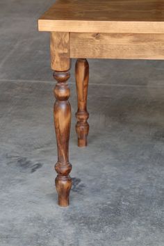 a wooden table sitting on top of a cement floor