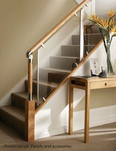 a vase with flowers sitting on top of a table next to a stair banister