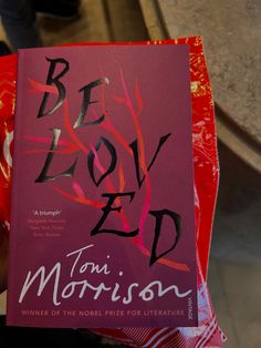 a person holding up a book in their hand that reads be loved by tom morrison