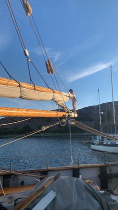 a man standing on the side of a sail boat