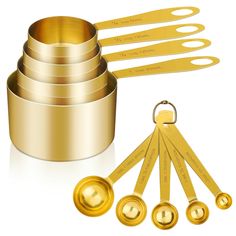 gold measuring cups and spoons are arranged next to each other