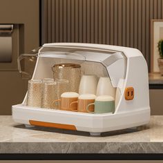 a white toaster oven sitting on top of a counter next to a cup holder