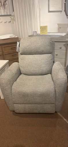 a recliner chair sitting on top of a carpeted floor next to a dresser