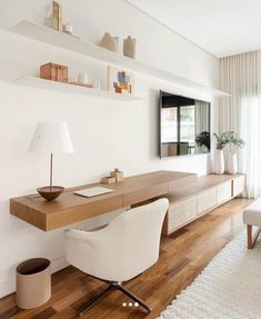 a living room with white walls and wooden flooring on the side, along with a large window