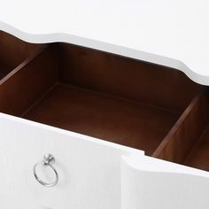 an open drawer with two rings on the bottom and one ring at the bottom, in front of a white wall