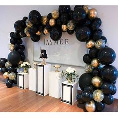 a black and gold balloon arch for a birthday party