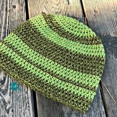 a green and brown hat sitting on top of a wooden table