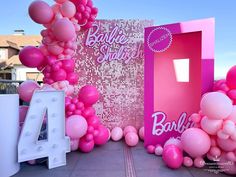 pink balloons are in front of a barbie birthday sign and balloon arch with the number 4 on it