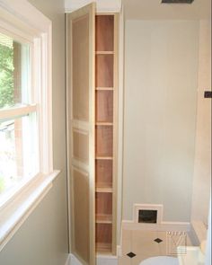 a bathroom with a toilet and shelves in it