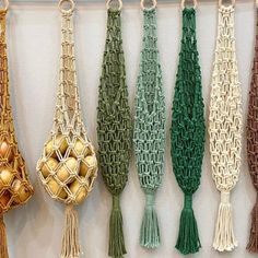 several tassels are hanging on the wall with gold balls in them and green cords