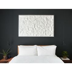 a bed with white sheets and pillows in front of a painting on the wall above it