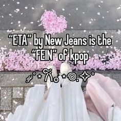 a person standing on top of a sidewalk with pink flowers in the background and text that reads,'eta by new jeans is the ten of kpop