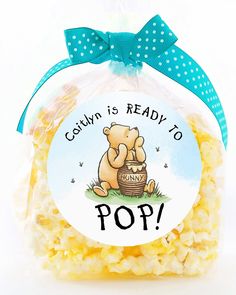 a bag filled with popcorn sitting on top of a white table next to a blue bow