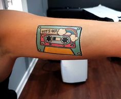 a person with a tattoo on their arm that has a cassette tape design on it