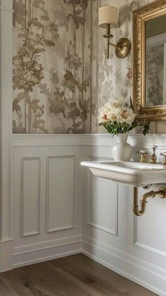 a white sink sitting under a bathroom mirror next to a wall mounted faucet