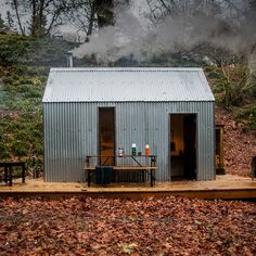 a small metal building sitting on top of a wooden platform