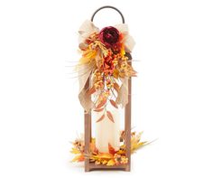 a lantern with fall leaves and flowers on it