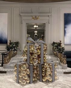 a large group of christmas presents sitting on top of each other in front of a staircase