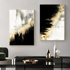 two black and gold paintings hang on the wall above a dining room table with chairs