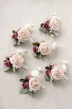 small pink and white flowers are arranged on a table