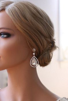 a mannequin head wearing a white dress with earrings on it's ear