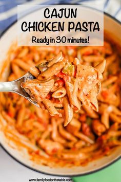 a spoon full of chicken pasta with the words cajun chicken pasta ready in 30 minutes