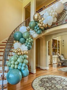 a spiral staircase decorated with balloons and blue, gold and white colors in a living room