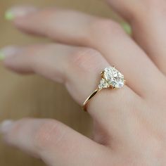 a woman's hand with a diamond ring on top of her finger, showing the center stone