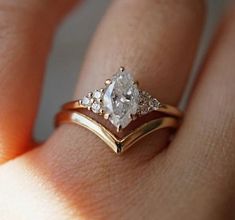 a woman's hand with a gold and white diamond ring on top of her finger