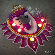 a decorated diya with lit candles on the ground