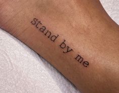 a person's arm with the words stand by me tattooed on it