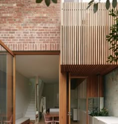 a brick building with wooden slats on the roof and walls, as well as an open living area