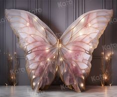 a large white butterfly sitting on top of a table next to some candles and lights