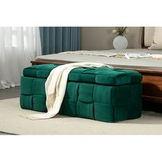 a green ottoman sitting on top of a bed