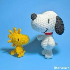 a small crocheted dog next to a toy giraffe on a blue background