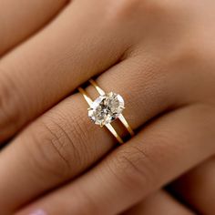 a woman's hand with a ring on it and a diamond in the middle