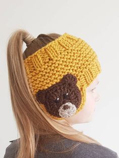 a woman wearing a knitted hat with a teddy bear on it's side